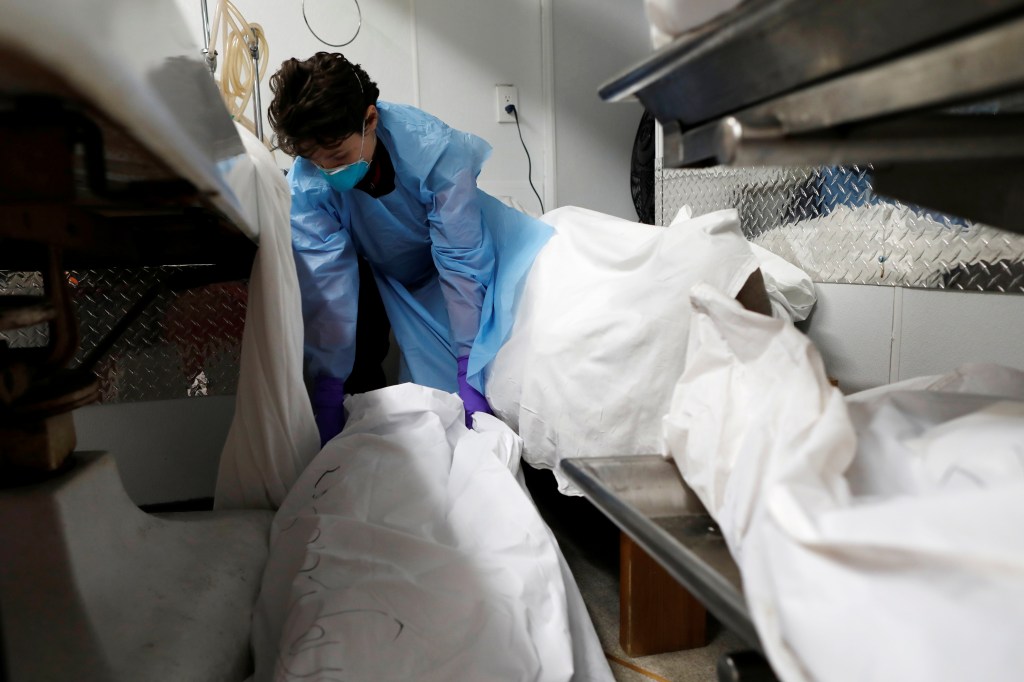 A resident funeral director at a NYC funeral home moves a deceased person in April 2020, just as the COVID-19 pandemic is starting. The virus is no longer the leading cause of death for Americans, falling from fourth in 2022 to 10th in 2023.