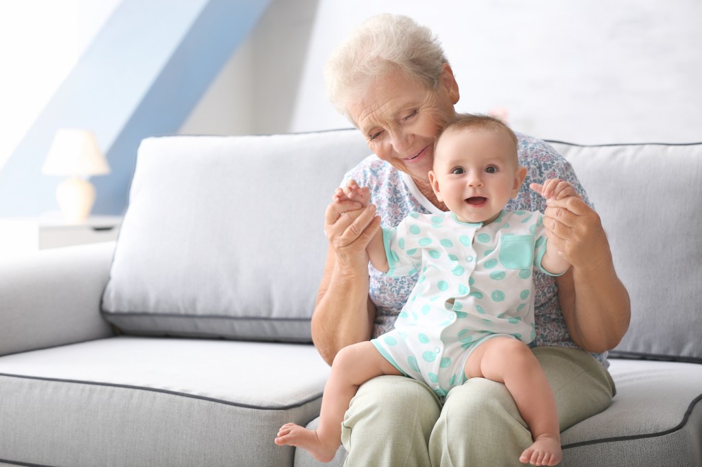 Elderly woman happily engaging in playtime with her little grandson at home