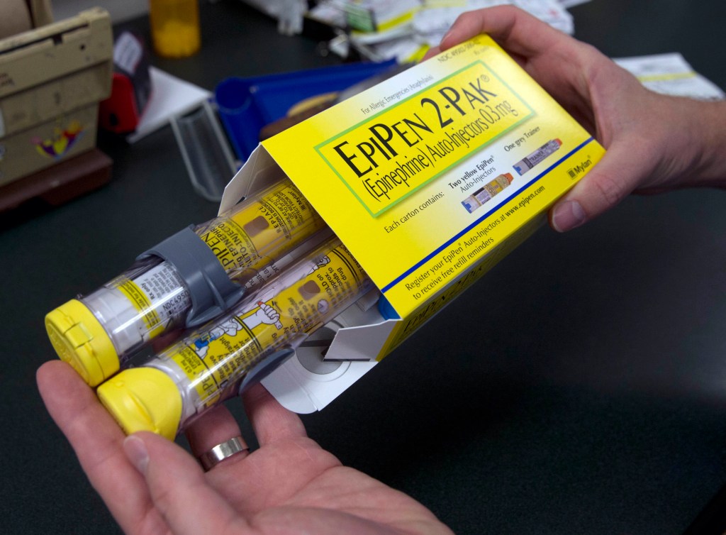 In this July 8, 2016 file photo, a pharmacist holds a package of EpiPens epinephrine auto-injectors, a Mylan product, in Sacramento, California